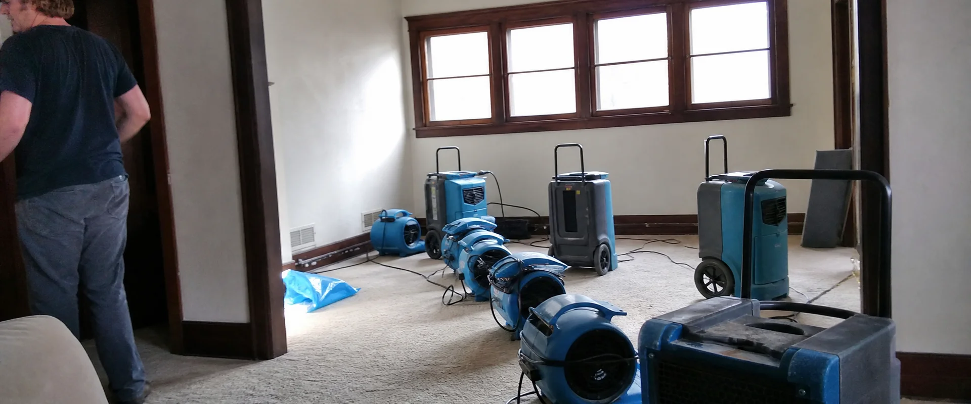 Air movers and dehumidifiers drying a contained room