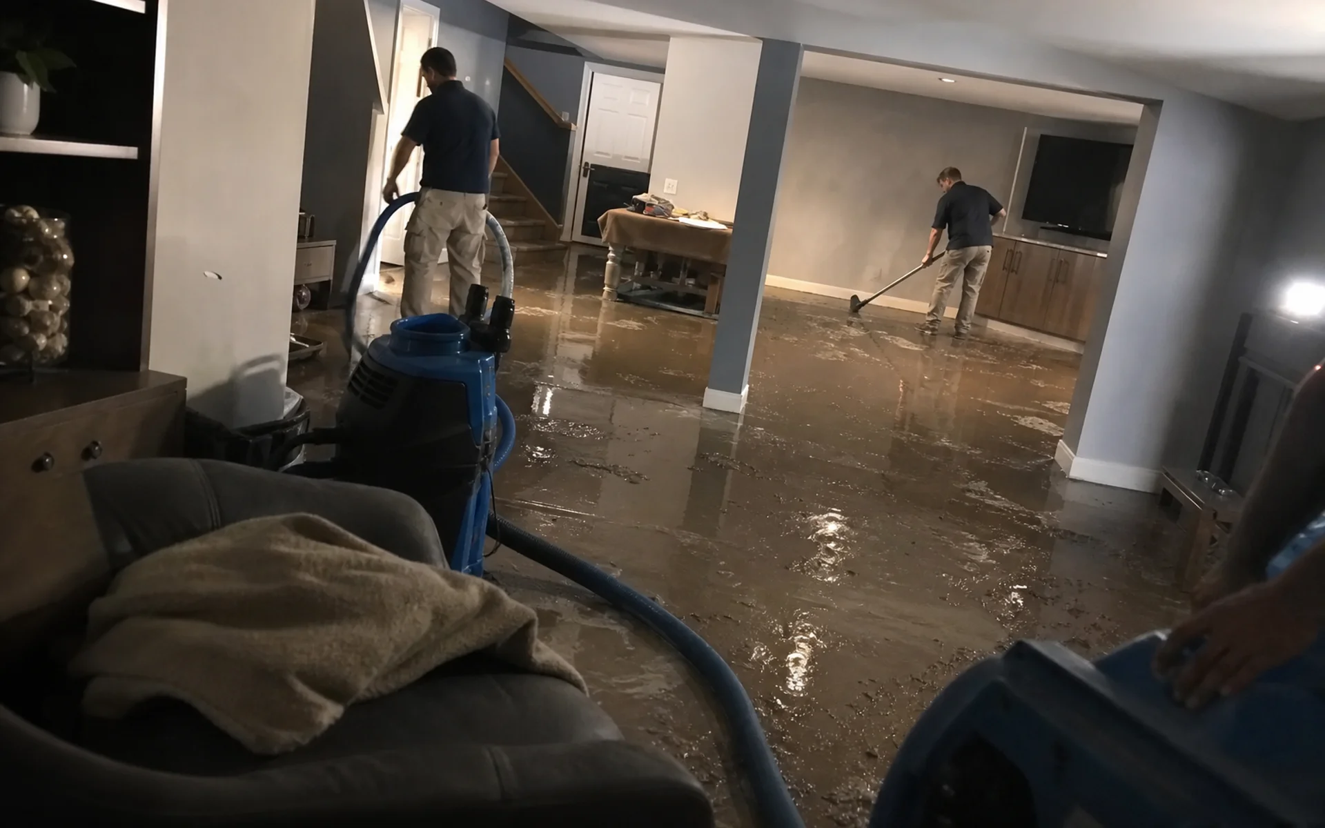 IICRC certified restoration crew extracting water from a flooded Castle Rock basement at night