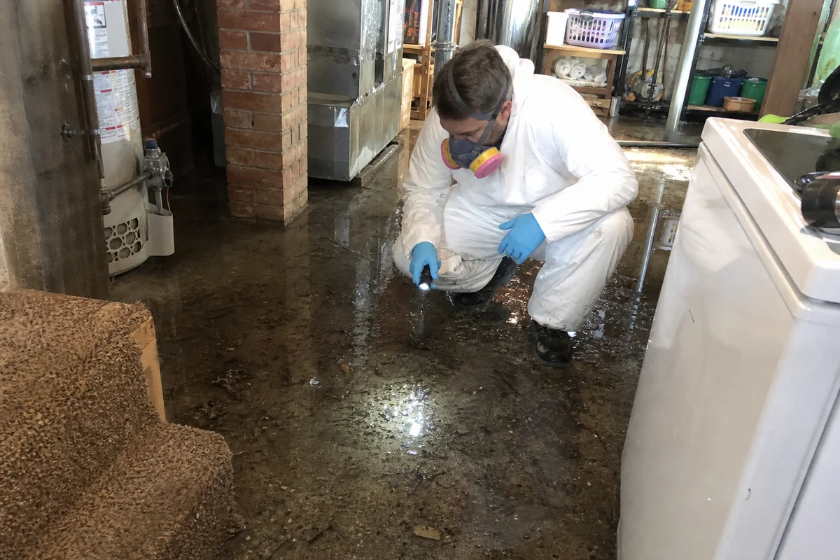 Technician in PPE inspecting contaminated water